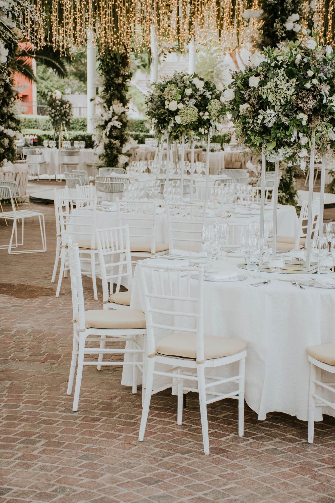 A banquet room dressed with white florals and hanging greenery