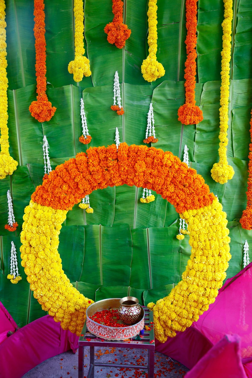 A traditional backdrop of banana leaf and marigold garlands