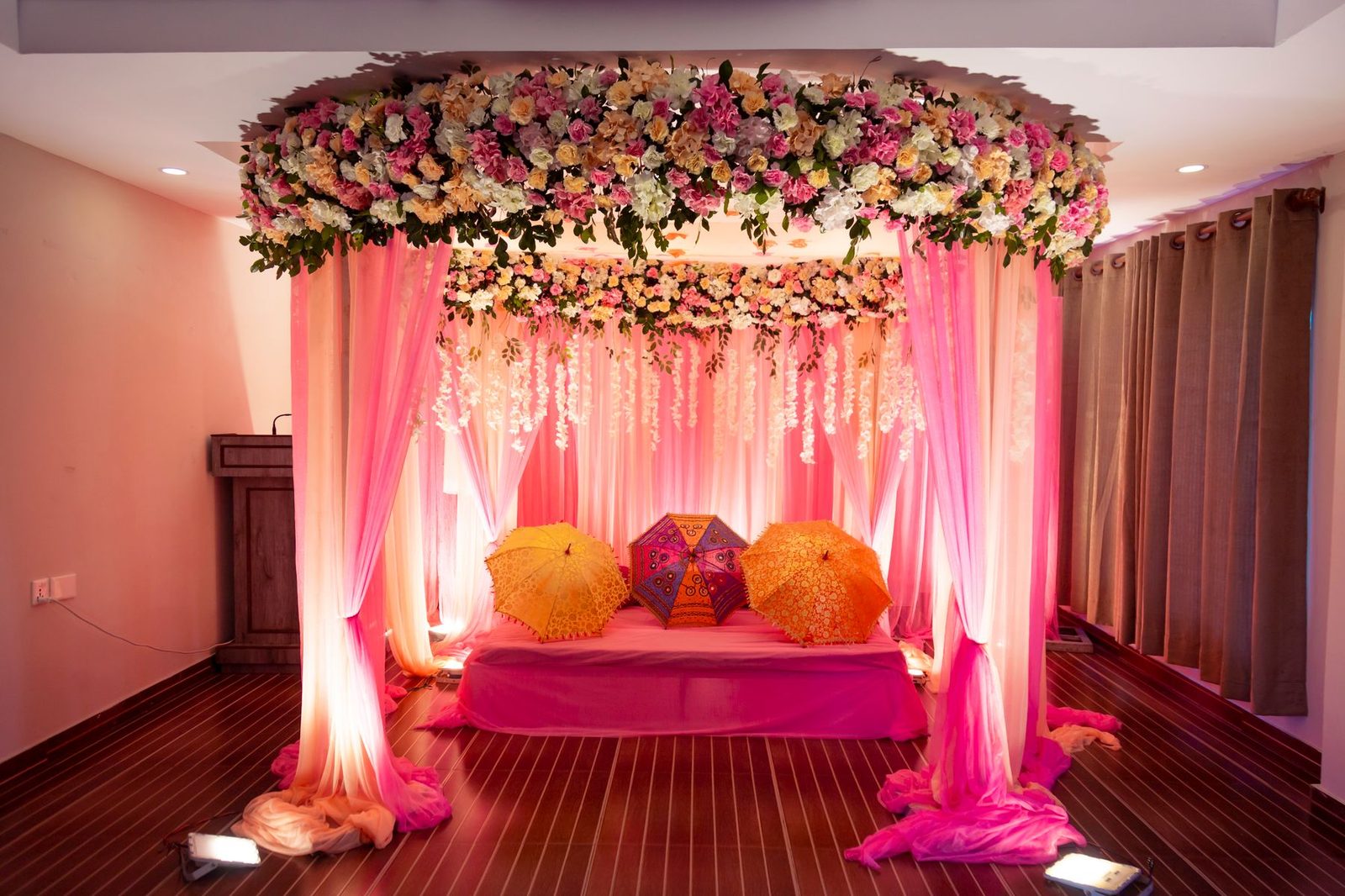 A sangeet stage draped in pink and gold